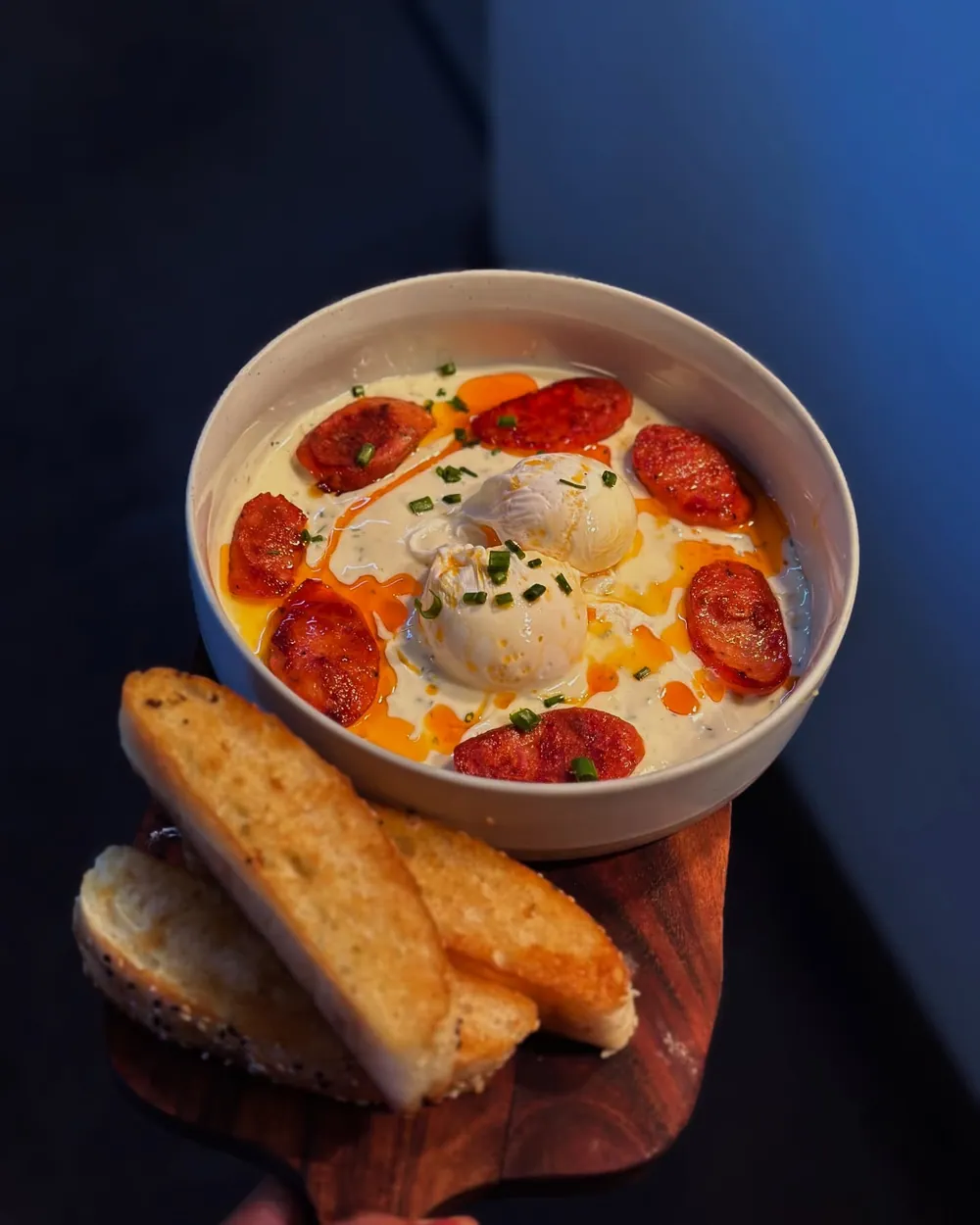 Poached eggs with chorizo and chilli oil over garlic yoghurt, toasted bread alongside